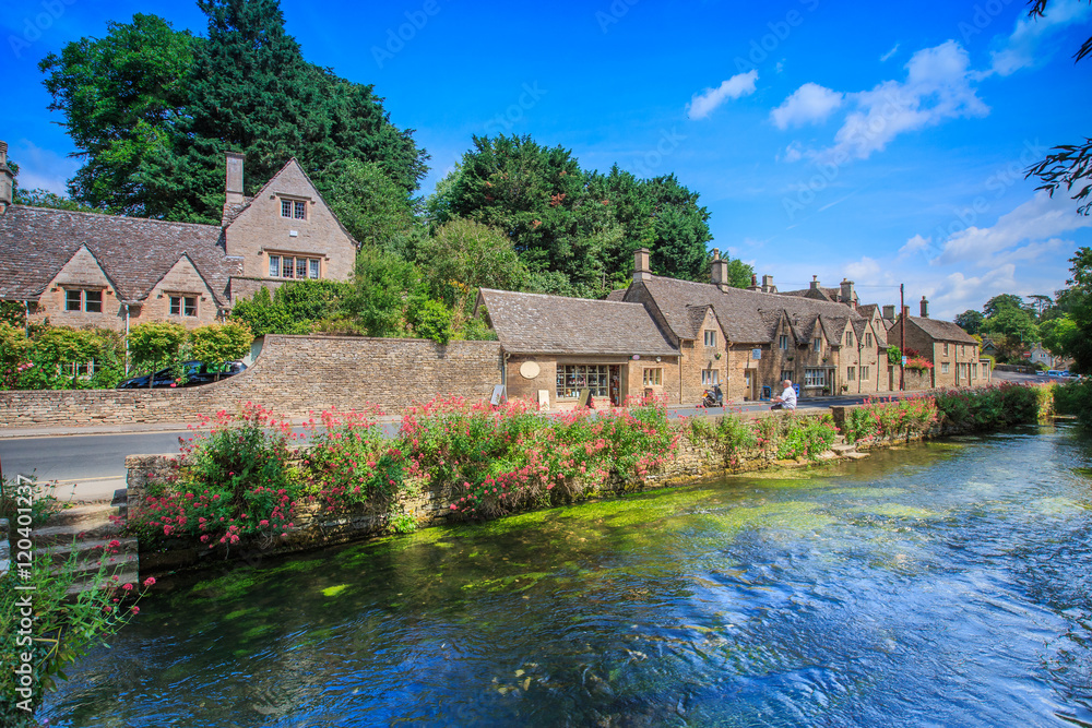 BIBURY, ENGLAND, UK - JULY 9, 2014: Arlington Row traditional Cotswold  stone cottages in Gloucestershire on JULY 9, 2014, England. Bibury it the  most depicted village in the world. Stock Photo