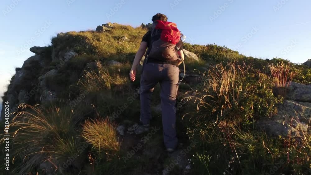 young woman hiking, walking, trekking outdoors on mountain trail path in sunny day, 4k front pov (point of view)