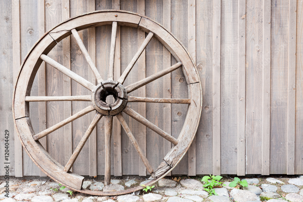 Old cartwheel leaning against wall Old cartwheel leaning against wall