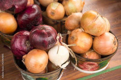 Different types of onions in baskets at the market