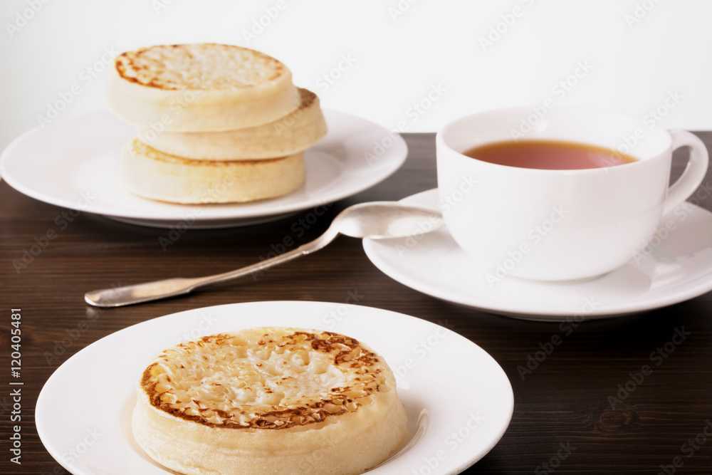 Tea and crumpets on a dark wooden table Tea and crumpets on a dark wooden table