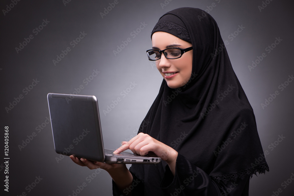Muslim woman in black dress against dark background Muslim woman in black dress against dark background