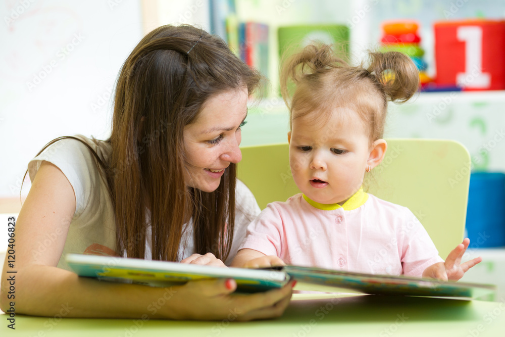 Happy mother and daughter reading a book together Happy mother and daughter reading a book together