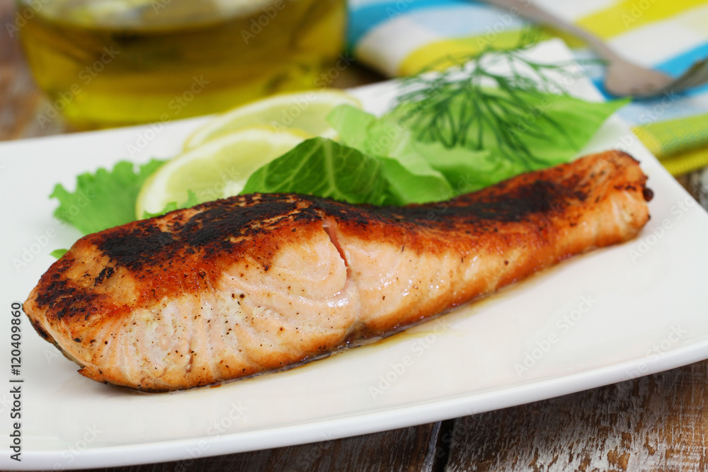 Grilled salmon steak with green salad and lemon on white plate
Grilled salmon steak with green salad and lemon on white plate
