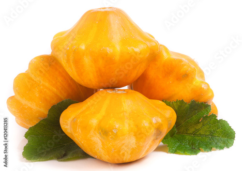 four yellow pattypan squash with leaf isolated on white background