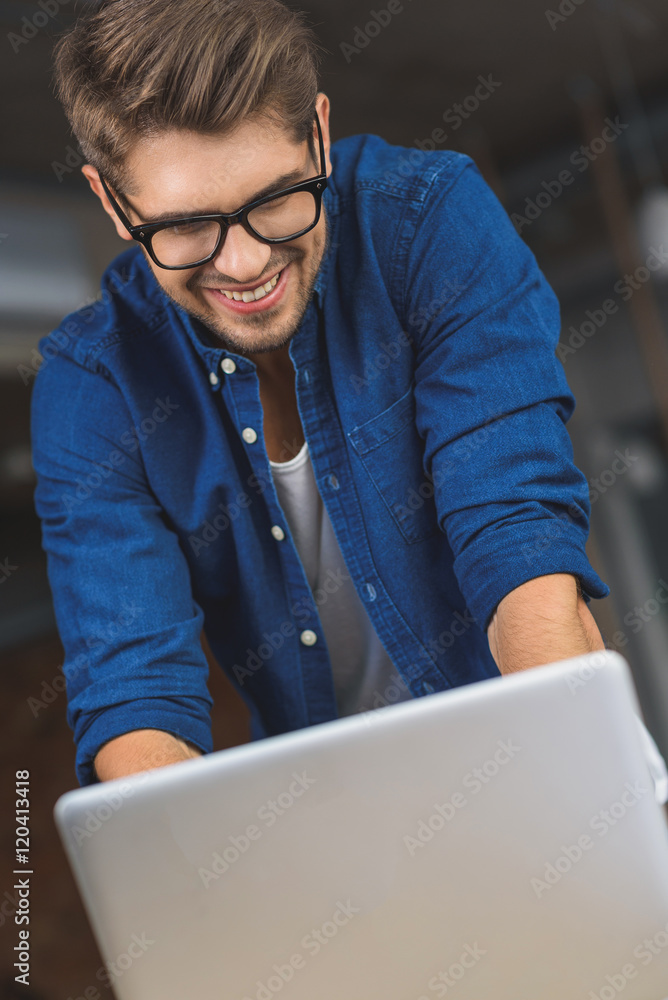 freelancer in glasses typing on a laptop