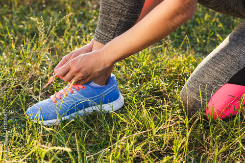 Konstfotografi Body part: Sportswoman ties shoelaces on her shoes