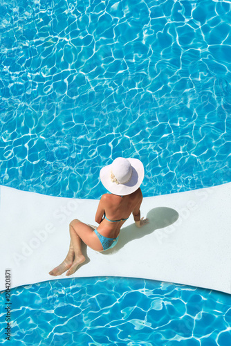 beautiful tanned sporty slim woman relaxing in swimming pool