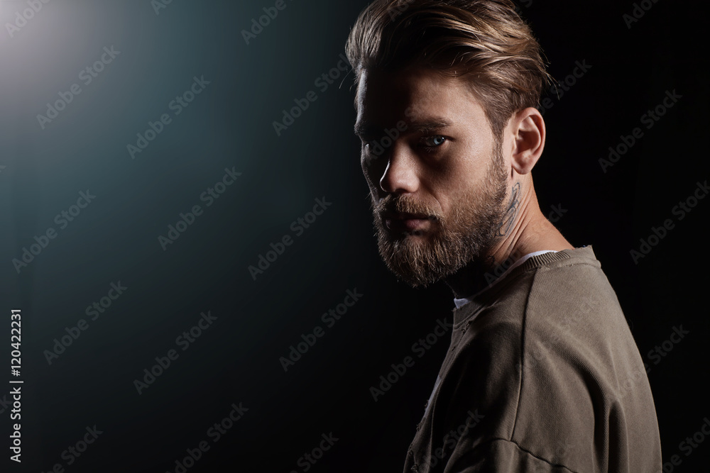 Fototapeta premium Portrait of a handsome man in a green t-shirt from the back