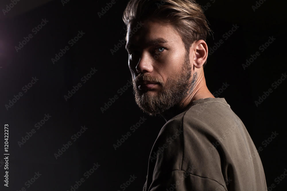 Portrait of a handsome man in a green t-shirt from the back