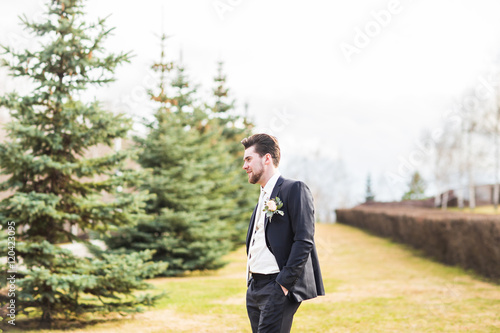 groom in autumn park at a wedding day