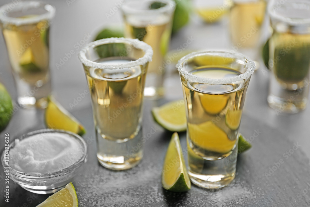 Shots of gold tequila with lime slices and salt on a tray Shots of gold tequila with lime slices and salt on a tray