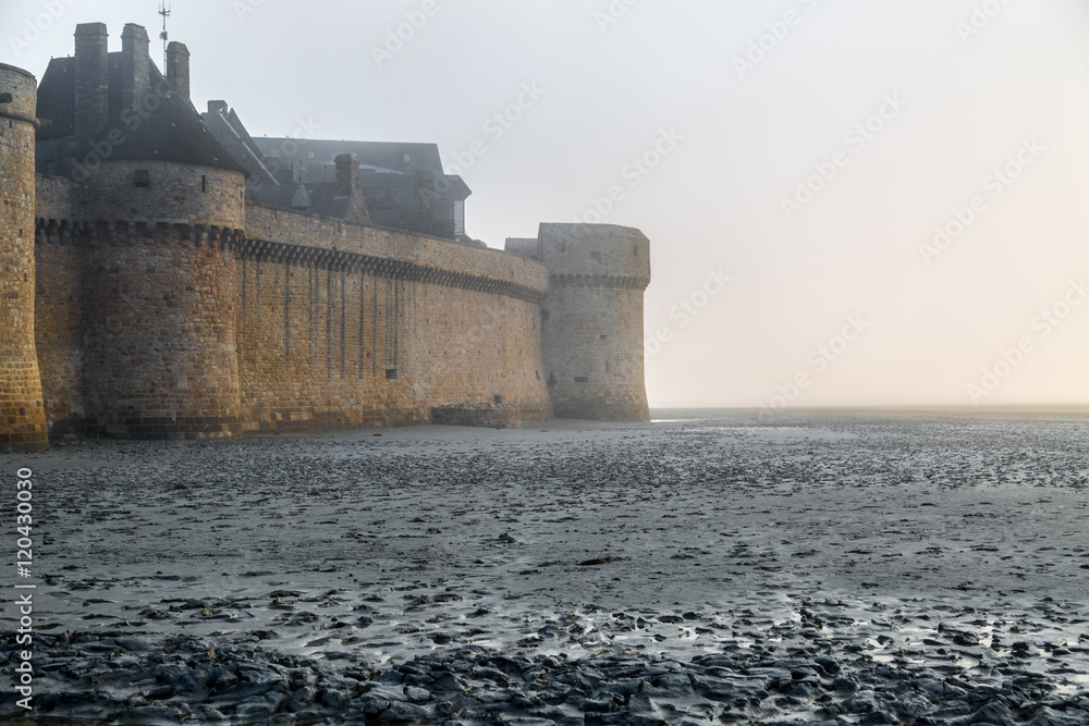 Gothic castle on the Norman coast in foggy sunrise
