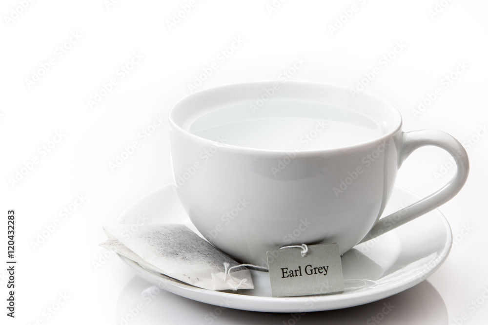 White cup and saucer with an earl grey tea bag on a white backgr