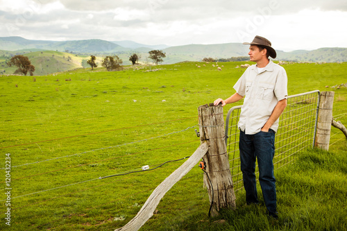 Aussie farmer looking out over a sheep paddock
