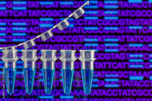 PCR tubes with nucleic acid sequence and bands in the background photo