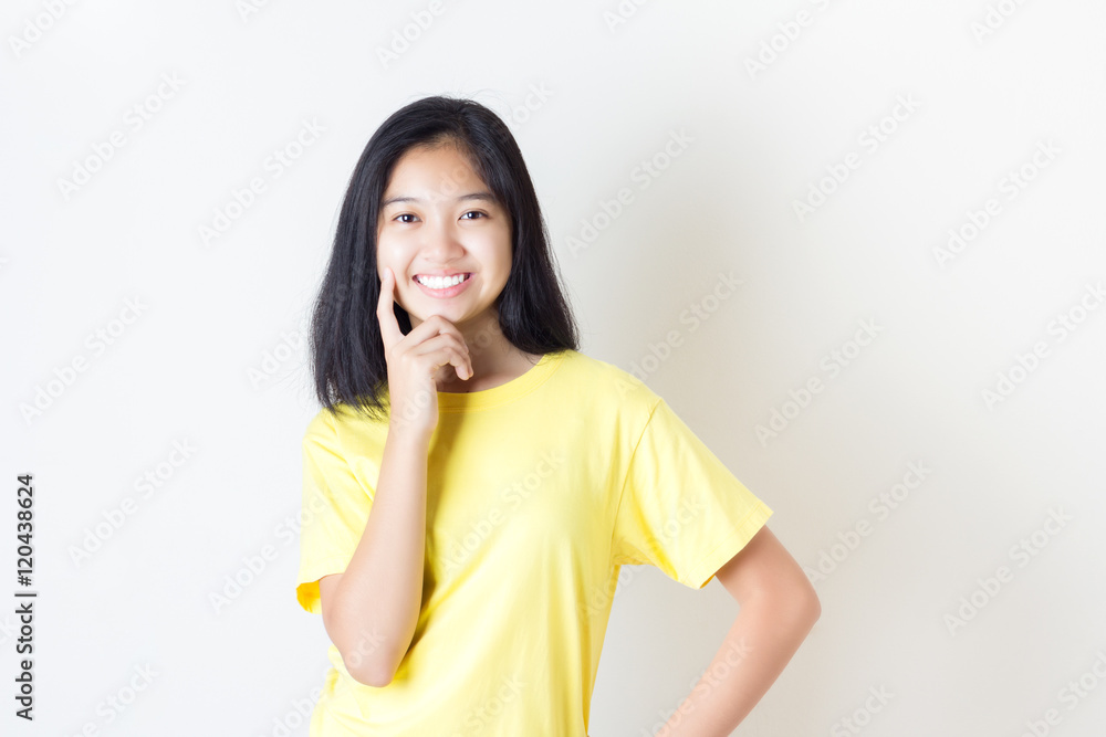 Contemplative young woman / Asian woman in yellow t-shirt on whi Contemplative young woman / Asian woman in yellow t-shirt on whi