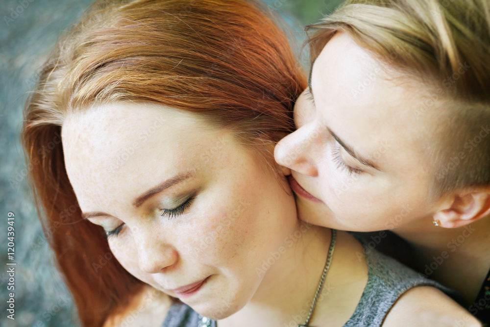 LGBT women. Young lesbian couple walking in the park together. Delicate relationship. Selective focus. LGBT women. Young lesbian couple walking in the park together. Delicate relationship. Selective focus.