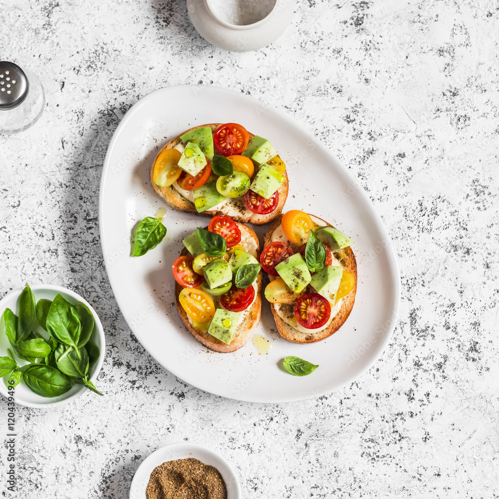 Bruschetta with cherry tomatoes, avocado and basil. On a light background. Healthy snack Bruschetta with cherry tomatoes, avocado and basil. On a light background. Healthy snack