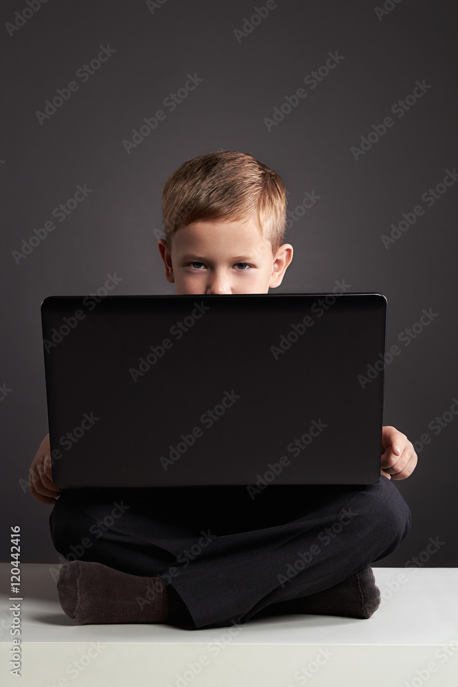 Young boy with computer. funny child looking in notebook. education technology Young boy with computer. funny child looking in notebook. education technology