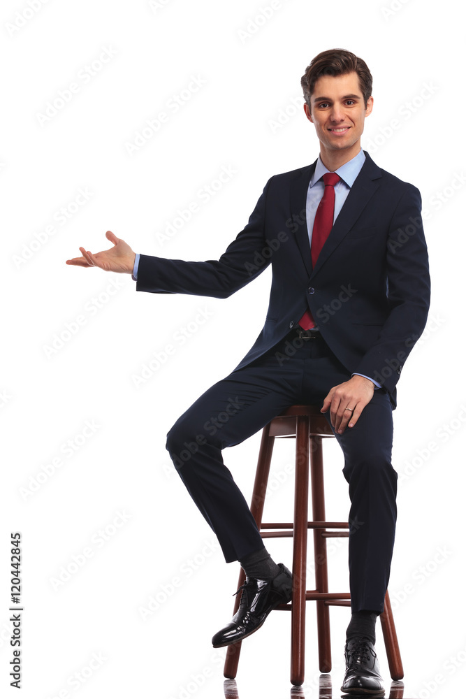 smiling seated businessman is presenting smiling seated businessman is presenting