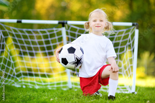 Cute little soccer player having fun playing a soccer game © MNStudio