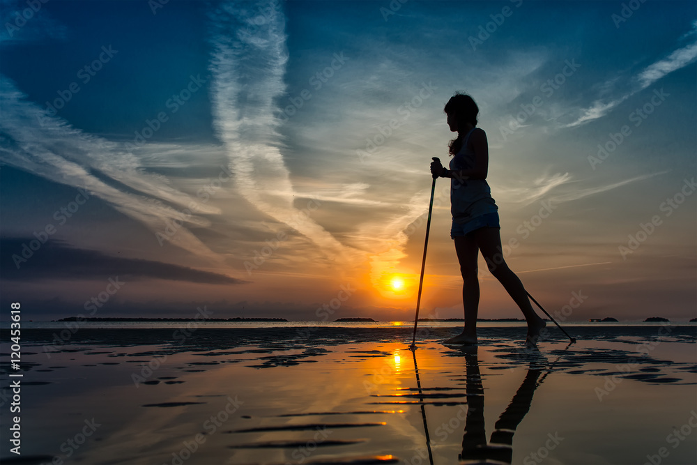 Nordic walking in the beach at sunrise