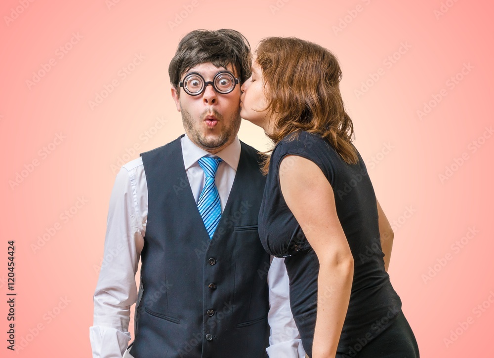 Surprised nerd is being kissed by pretty woman. Surprised nerd is being kissed by pretty woman.