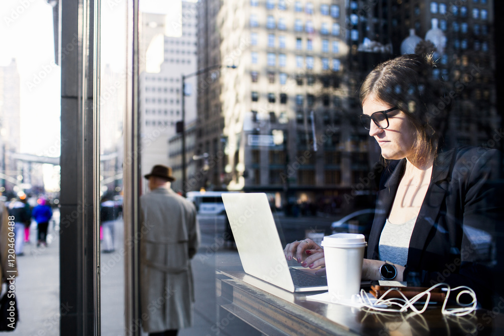 Businesswoman using laptop while sitting at coffee shop Businesswoman using laptop while sitting at coffee shop