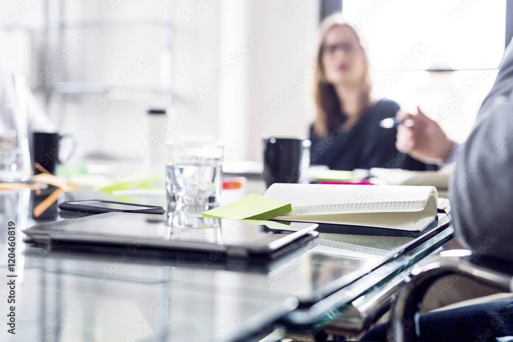 Close-up of laptop and books on conference table during meeting