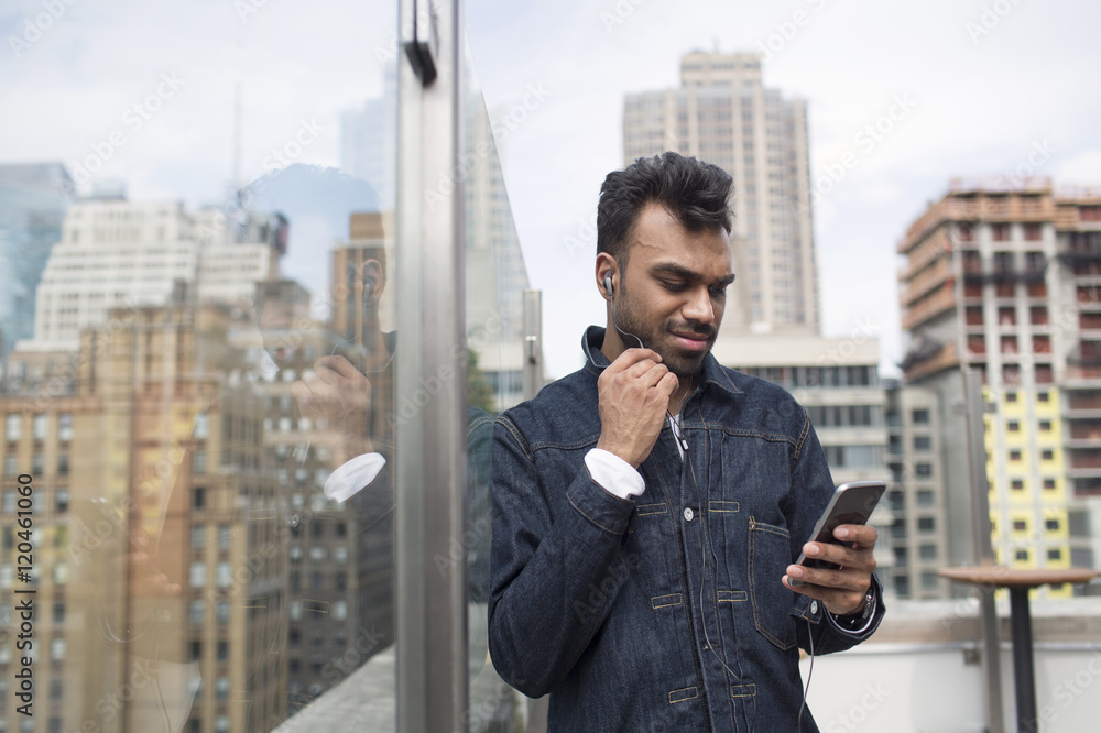 Man using phone while standing by glass window at rooftop restaurant Man using phone while standing by glass window at rooftop restaurant