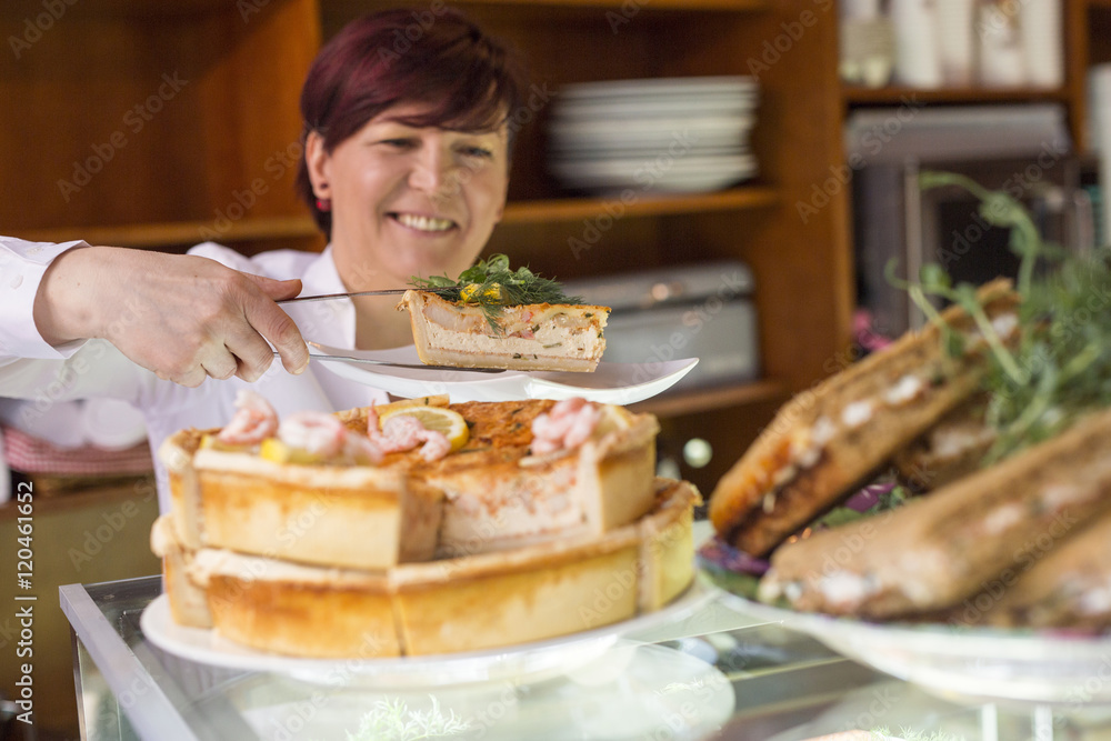 Sweden, Stockholm, Gamla Stan, Smiling woman serving tart in cafe Sweden, Stockholm, Gamla Stan, Smiling woman serving tart in cafe