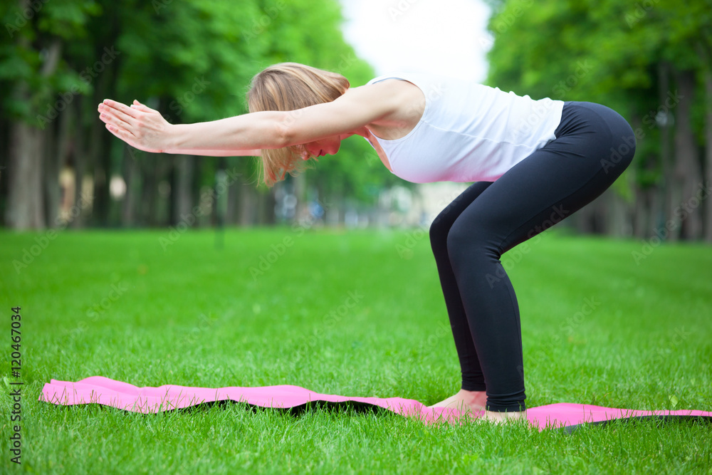 Young woman is stretching in the park.