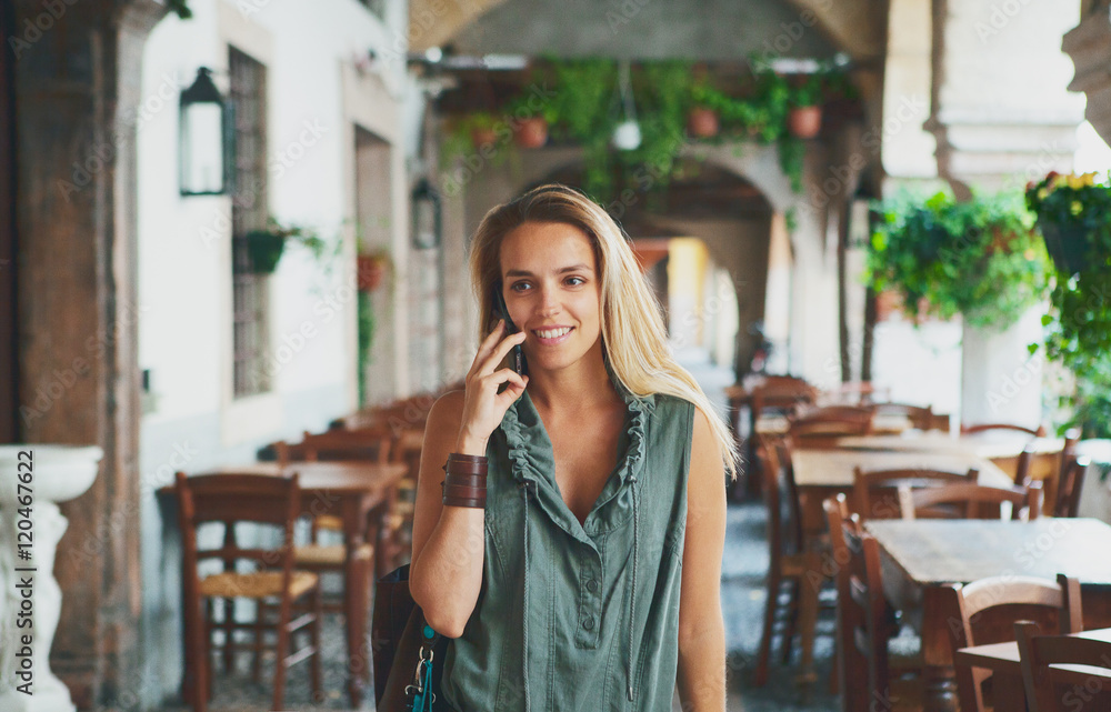 Donna bionda passeggia e parla al telefono Donna bionda passeggia e parla al telefono