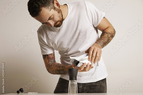 Man with a coffee grinder and bag of coffee beans photo