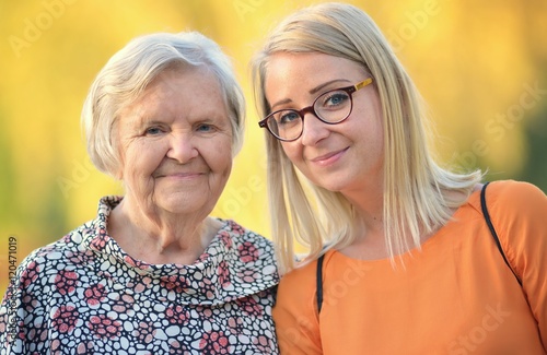 Grandmother and granddaughter. Young woman carefully takes care