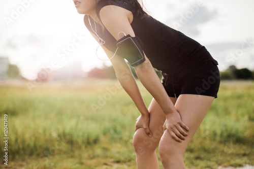 Φωτογραφία Young woman leaning over in sports gear.