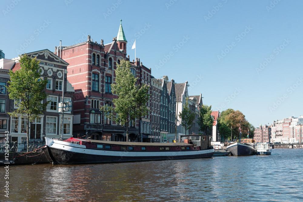 Houses and barges on the river Amstel in Amsterdam