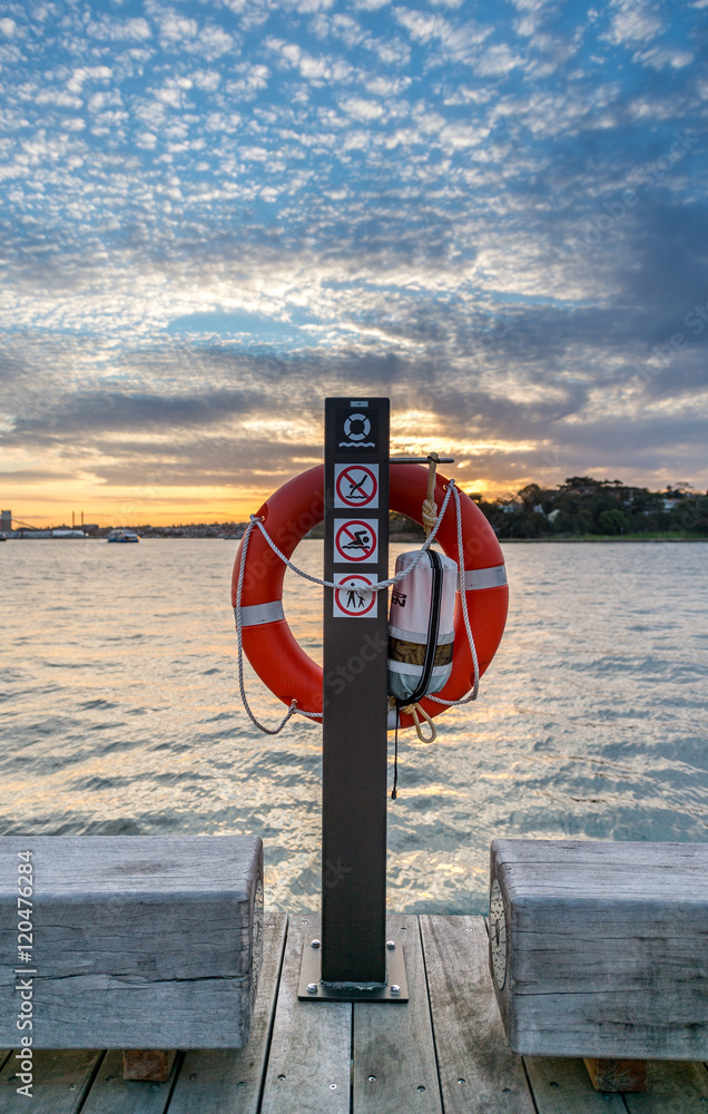Life Preserver on pole with sunset in background