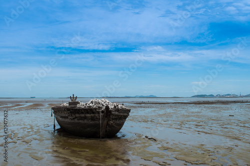 An old rowing boat in need of repair on the beach