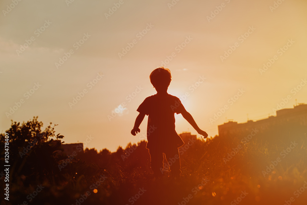 Fototapeta premium silhouette of little boy running at sunset