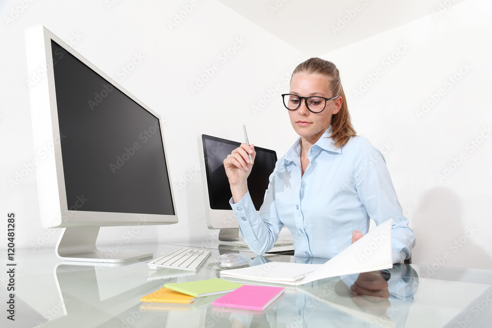 woman in office at desk with notebook and pencil, reading notes woman in office at desk with notebook and pencil, reading notes