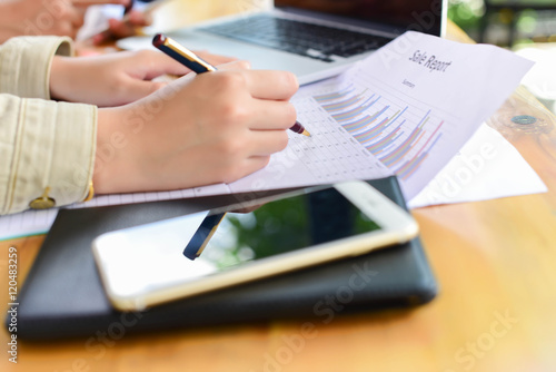 female hands over business document with graph and chart to cofe