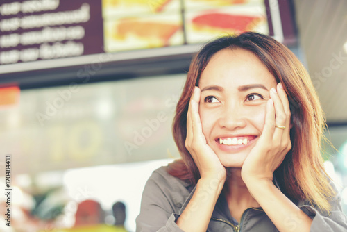 Overworked young woman sitting at the desk and holding his head