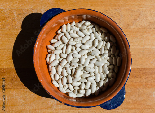 Fagioli in una scodella su tavola di legno photo