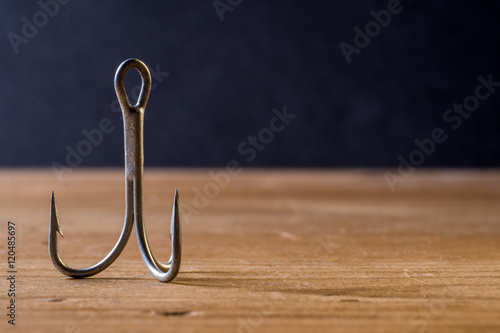 Fish Hook on a wooden surface with dark background