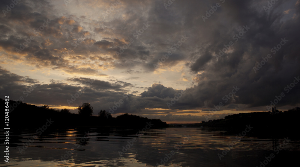 Panorama of sunset over the river with clouds late at night.