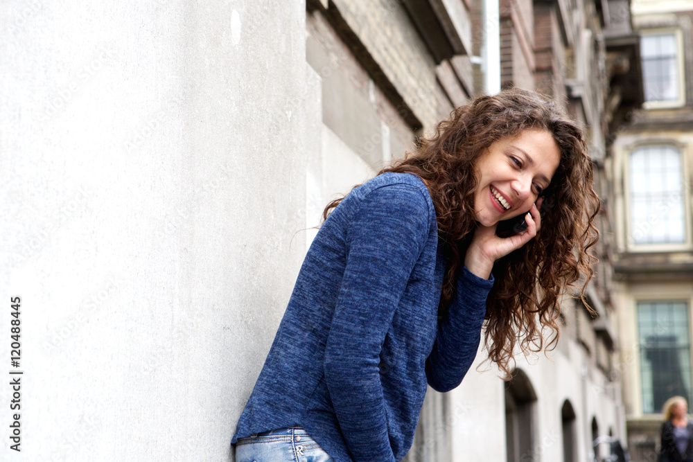 Young woman talking on mobile phone and smiling outdoors Young woman talking on mobile phone and smiling outdoors