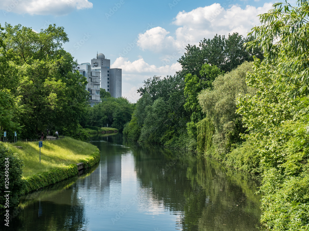 Canal in Berlin with trees on sides, building in background