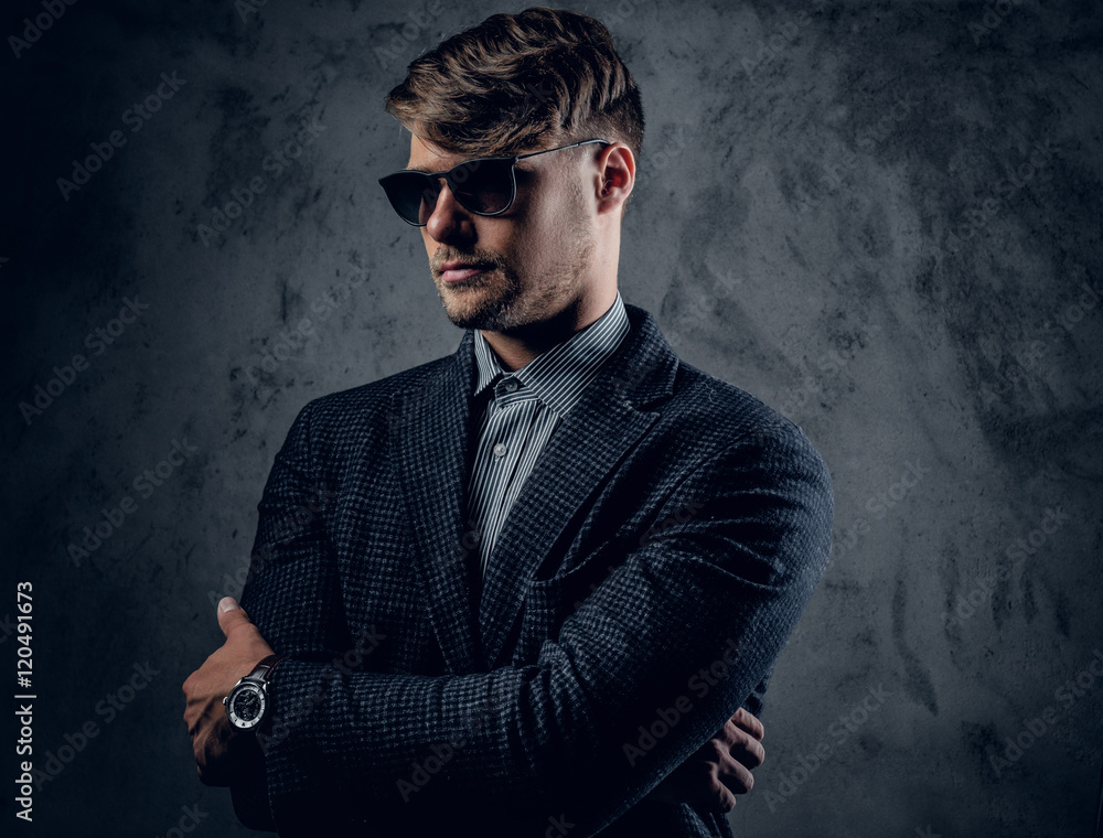 A man in a suit and sunglasses on grey background. A man in a suit and sunglasses on grey background.